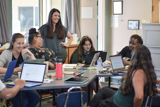 An iDEAL Program Coordinator Leading a workshop with teachers and their laptops.